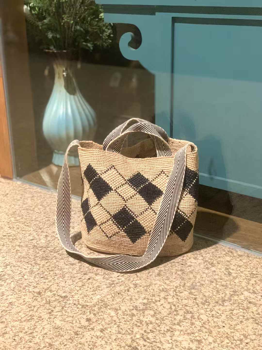 Raffia Bag in classic tote shape, flat bottom, black diamond pattern, wide, black-and-white striped handles and long cotton strap