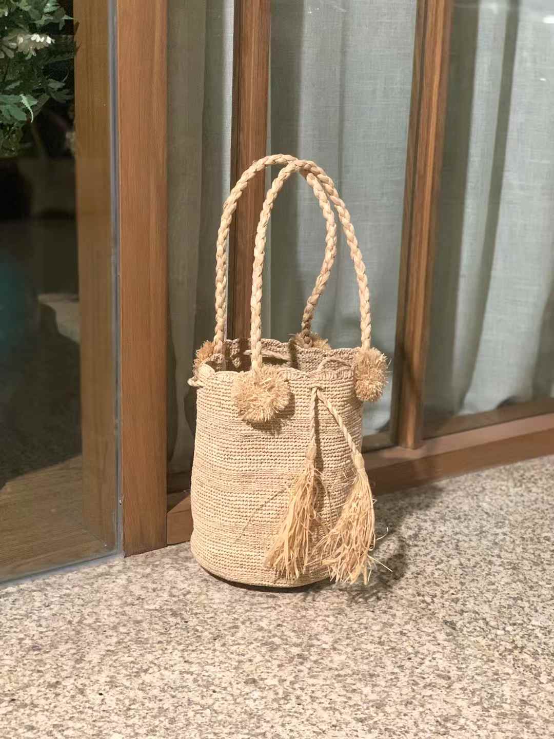 crochet raffia bucket with 2 handles, drawstring and pompom decor